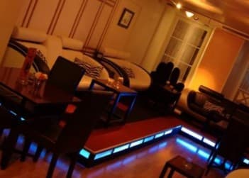 Gemütliche Lounge mit warmem Licht und Sitzecken im Happiness